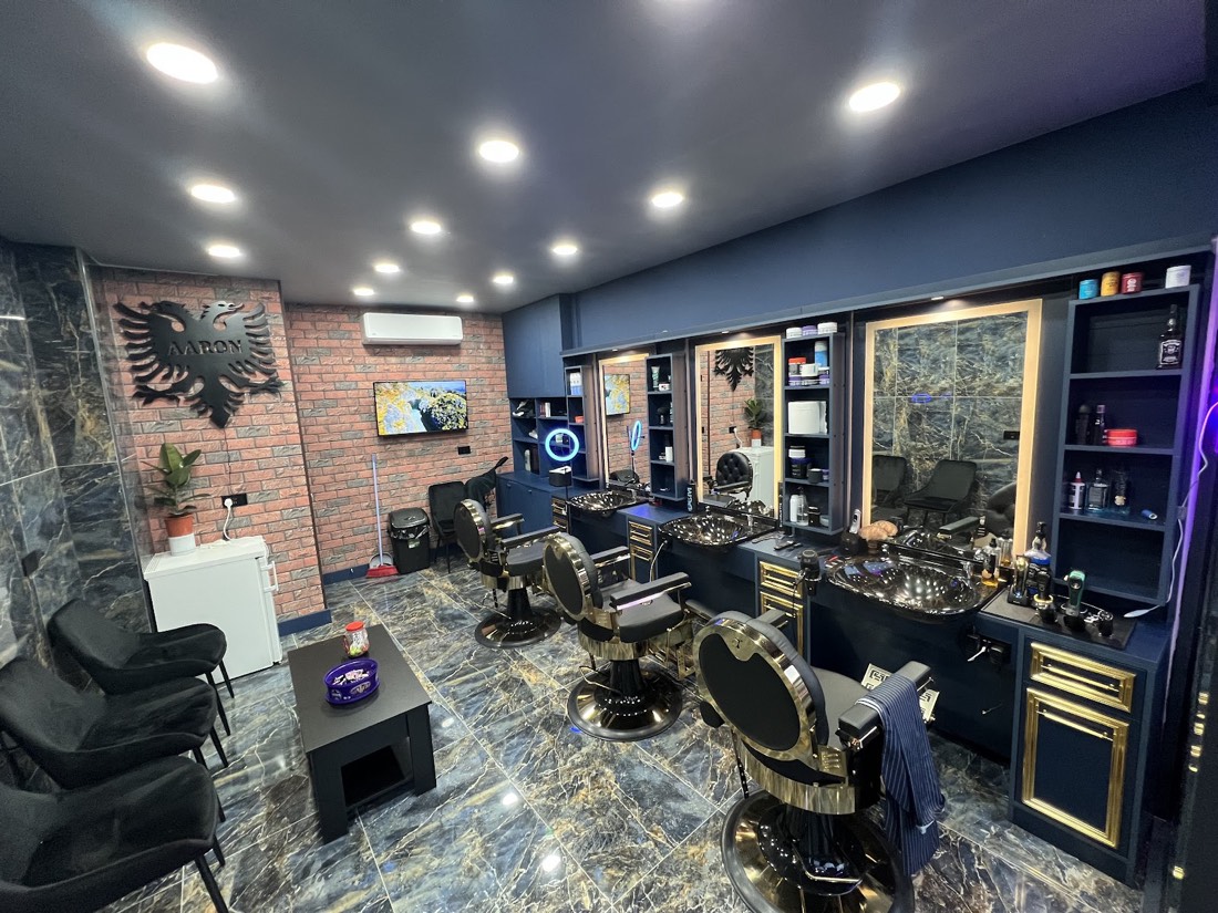 Inside Aaron Barber: brass barber chairs, brick feature wall and the black eagle wall art
