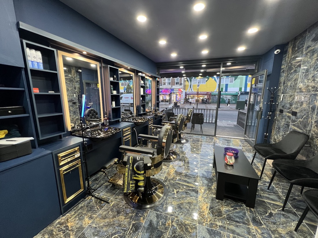 Barber stations at Aaron Barber with marble surfaces and gold-trimmed cabinets